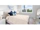 Bright bedroom featuring a comfortable queen bed, stylish decor, and a large window with natural light at 18001 Grand Prosperity Dr, Venice, FL 34293