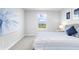 Bright bedroom with a striped bedspread, decorative pillows, and a serene window view at 18001 Grand Prosperity Dr, Venice, FL 34293