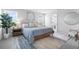 Bright bedroom with a plush bed, modern rug, stylish nightstands, and ensuite bathroom access at 18001 Grand Prosperity Dr, Venice, FL 34293