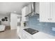 Chic kitchen with white cabinetry, quartz countertops, blue backsplash, and stainless steel appliances at 18001 Grand Prosperity Dr, Venice, FL 34293