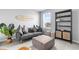 Comfortable living room with gray sofa, decorative surfboard wall art, and stylish bookshelf with cabinet storage at 18001 Grand Prosperity Dr, Venice, FL 34293