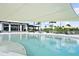 Resort-style pool featuring lounge chairs, umbrellas, and stunning clubhouse backdrop at 18001 Grand Prosperity Dr, Venice, FL 34293