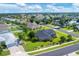 An aerial view of the home's backyard featuring mature trees and landscaping, and the surrounding neighborhood at 2000 Jasmine Way, North Port, FL 34287