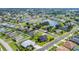 Aerial view showcases a neighborhood with lush green lawns, mature trees, and a few ponds at 2000 Jasmine Way, North Port, FL 34287