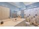 Bathroom features a vanity with a large mirror, nautical decor, and a shower with a seashell-themed curtain at 2000 Jasmine Way, North Port, FL 34287