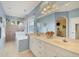 Well-lit bathroom features a dual sink vanity, soaking tub, separate shower, and neutral tile flooring at 2000 Jasmine Way, North Port, FL 34287