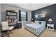 Serene bedroom with a black accent wall, decorative lamps, a bookshelf, and a white chair at 2000 Jasmine Way, North Port, FL 34287