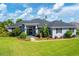 Well-maintained house features lovely landscaping, a water fountain, and neutral exterior paint at 2000 Jasmine Way, North Port, FL 34287