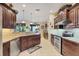 Bright kitchen featuring stainless steel appliances, granite counters, wood cabinets, and open access to outside area at 2000 Jasmine Way, North Port, FL 34287