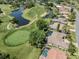 View of a golf course community with single-Gathering homes surrounding a large pond at 2022 Calusa Lakes Blvd, Nokomis, FL 34275