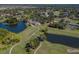 Aerial view showcasing the golf course, lakes, tennis courts, and clubhouse amenities at 2022 Calusa Lakes Blvd, Nokomis, FL 34275