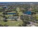 Expansive aerial view of community featuring golf course, lakes, tennis courts, and clubhouse amenities at 2022 Calusa Lakes Blvd, Nokomis, FL 34275