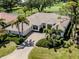 Aerial view of a home with a tile roof, a paver driveway, and mature landscaping at 2022 Calusa Lakes Blvd, Nokomis, FL 34275