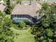 Aerial view of a home with a screened-in pool and mature landscaping at 2022 Calusa Lakes Blvd, Nokomis, FL 34275