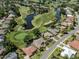 Aerial view of a single-Gathering home near a golf course and a large body of water at 2022 Calusa Lakes Blvd, Nokomis, FL 34275