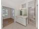 Bright bathroom with white cabinets, granite countertops, a large mirror, and an enclosed walk-in shower at 2022 Calusa Lakes Blvd, Nokomis, FL 34275