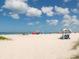 Beautiful sunny day on a white sandy beach with colorful umbrellas and people relaxing at 2022 Calusa Lakes Blvd, Nokomis, FL 34275
