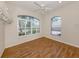 Empty bedroom with wood-look floors, light walls, white trim, and large windows with outdoor views at 2022 Calusa Lakes Blvd, Nokomis, FL 34275