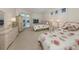 Cozy bedroom with twin beds, white dressers, light carpet, and views of the lush tropical landscaping at 2022 Calusa Lakes Blvd, Nokomis, FL 34275