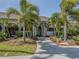 Clubhouse entrance framed by mature palm trees and lush landscaping for an inviting, tropical feel at 2022 Calusa Lakes Blvd, Nokomis, FL 34275