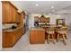 Modern kitchen with wood cabinets, granite countertops, stainless steel appliances, and tile flooring at 2022 Calusa Lakes Blvd, Nokomis, FL 34275