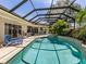 Inviting pool area with a screened enclosure, palm trees, and outdoor seating for relaxation and entertaining at 2022 Calusa Lakes Blvd, Nokomis, FL 34275