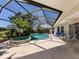 Screened-in pool and spa area surrounded by lush tropical landscaping at 2022 Calusa Lakes Blvd, Nokomis, FL 34275