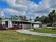 View of the home featuring an enclosed porch, a wooden deck and mature landscaping at 205 Jessica N St, Nokomis, FL 34275