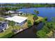 Aerial view of a waterfront property with a private dock, lush landscaping, and serene surroundings at 214 Pompano Ln, Nokomis, FL 34275