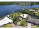 Aerial view of the home on the water featuring a private dock, mature trees, and neighboring houses at 214 Pompano Ln, Nokomis, FL 34275