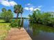 Dock overlooking the water, surrounded by lush greenery and mature trees, offering a serene atmosphere at 214 Pompano Ln, Nokomis, FL 34275