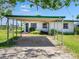 Charming single-story home with a convenient carport, lush lawn, and landscaping provides great curb appeal at 214 Pompano Ln, Nokomis, FL 34275