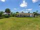 Charming single story home featuring a green lawn, well-manicured landscaping, and multiple windows at 214 Pompano Ln, Nokomis, FL 34275
