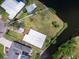 Aerial view of the property with a spacious yard, trees, and waterfront access at 214 Pompano Ln, Nokomis, FL 34275