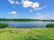 Beautiful lake view from the backyard with lush green grass and a serene atmosphere at 214 Pompano Ln, Nokomis, FL 34275