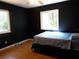 Bedroom features hardwood floors, two windows and dark walls at 2682 Yamada Ln, North Port, FL 34286