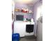 Bright laundry room with washer, dryer, storage shelf and natural light at 2682 Yamada Ln, North Port, FL 34286
