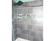 Modern shower with gray tile, mosaic accents, a rainfall showerhead, and stone floor at 2682 Yamada Ln, North Port, FL 34286