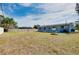 Wide shot of backyard showing the house, fenced perimeter and surrounding trees at 2980 Siesta Dr, Venice, FL 34293