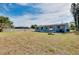 Wide backyard view showing the house exterior and grassy yard with perimeter fence at 2980 Siesta Dr, Venice, FL 34293