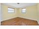 A sunlit bedroom features hardwood floors and two windows that let in lots of light at 2980 Siesta Dr, Venice, FL 34293