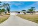 Single-story home featuring an attached garage, well-kept lawn, and a long driveway at 2980 Siesta Dr, Venice, FL 34293