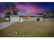 Charming single-story home with a well-manicured lawn and attached garage during sunset at 2980 Siesta Dr, Venice, FL 34293