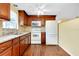 Kitchen features wood cabinets, white appliances, and hardwood flooring at 2980 Siesta Dr, Venice, FL 34293