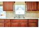 Bright kitchen featuring double bowl sink, granite countertops, and wood cabinets at 2980 Siesta Dr, Venice, FL 34293