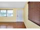 Bright room with hardwood floors, large window and a white door, filled with natural light at 2980 Siesta Dr, Venice, FL 34293