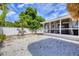 Backyard featuring a screened patio and well-maintained gravel, providing a private outdoor living area at 307 Bucknell Rd, Venice, FL 34293