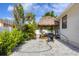 Landscaped backyard featuring a tiki hut with picnic table, perfect for outdoor gatherings and relaxation at 307 Bucknell Rd, Venice, FL 34293