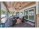 Inviting screened porch featuring comfortable seating, ceiling fan, and views of the backyard at 307 Bucknell Rd, Venice, FL 34293