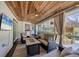 Comfortable screened porch with a lounge area, ceiling fan, and view of the backyard tiki hut at 307 Bucknell Rd, Venice, FL 34293